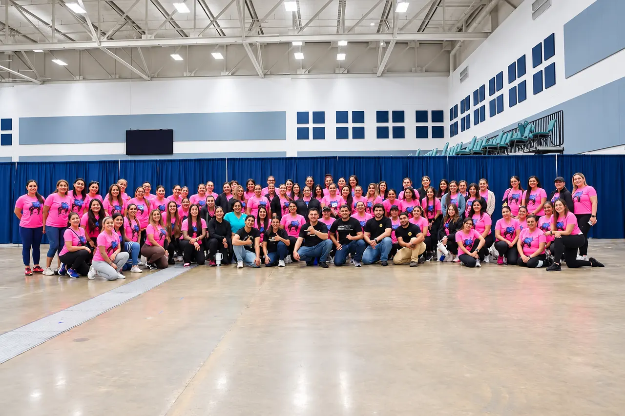 Professor Manny Galvan with a large group of female law enforcement officers in pink conference shirts