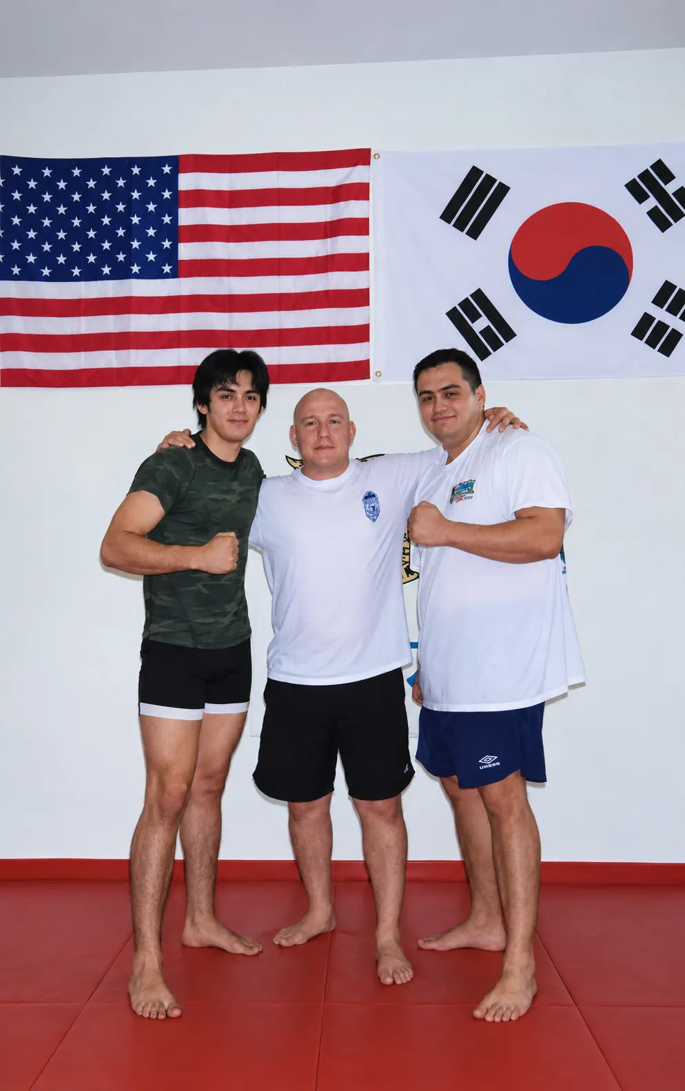 The Galvan brothers with Carlson Gracie Jr. in front of American and Korean flags