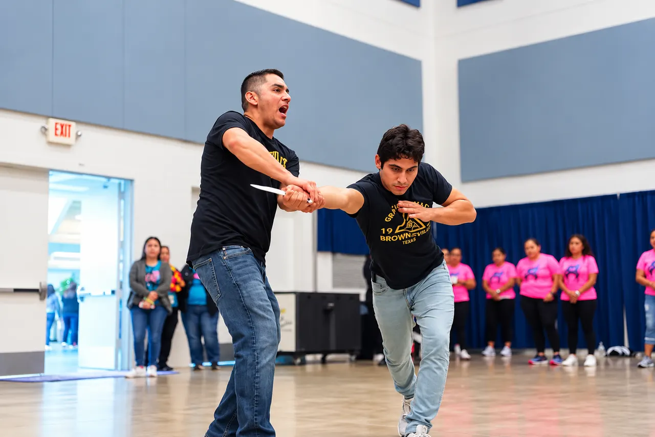 Manny Galvan and Professor Chris demonstrating a knife control defense in front of officers